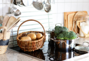 basket of potatoes and broccoli on solid surface countertop