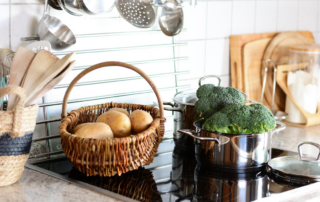 basket of potatoes and broccoli on solid surface countertop